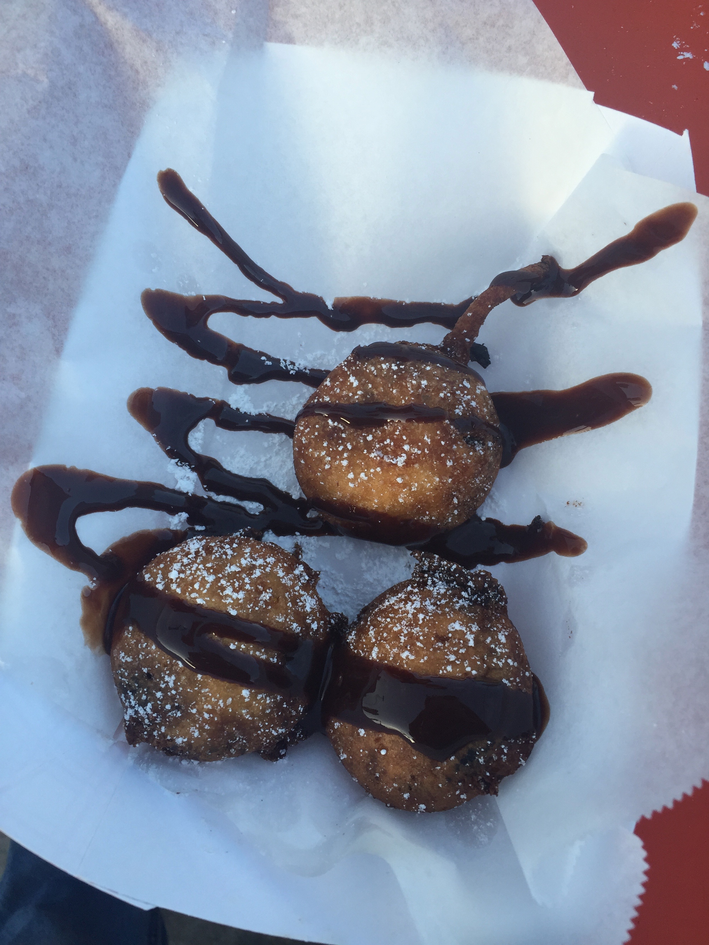 serving suggestion for deep fried oreos: lightly dusted with icing powder and drizzled in chocolate sauce