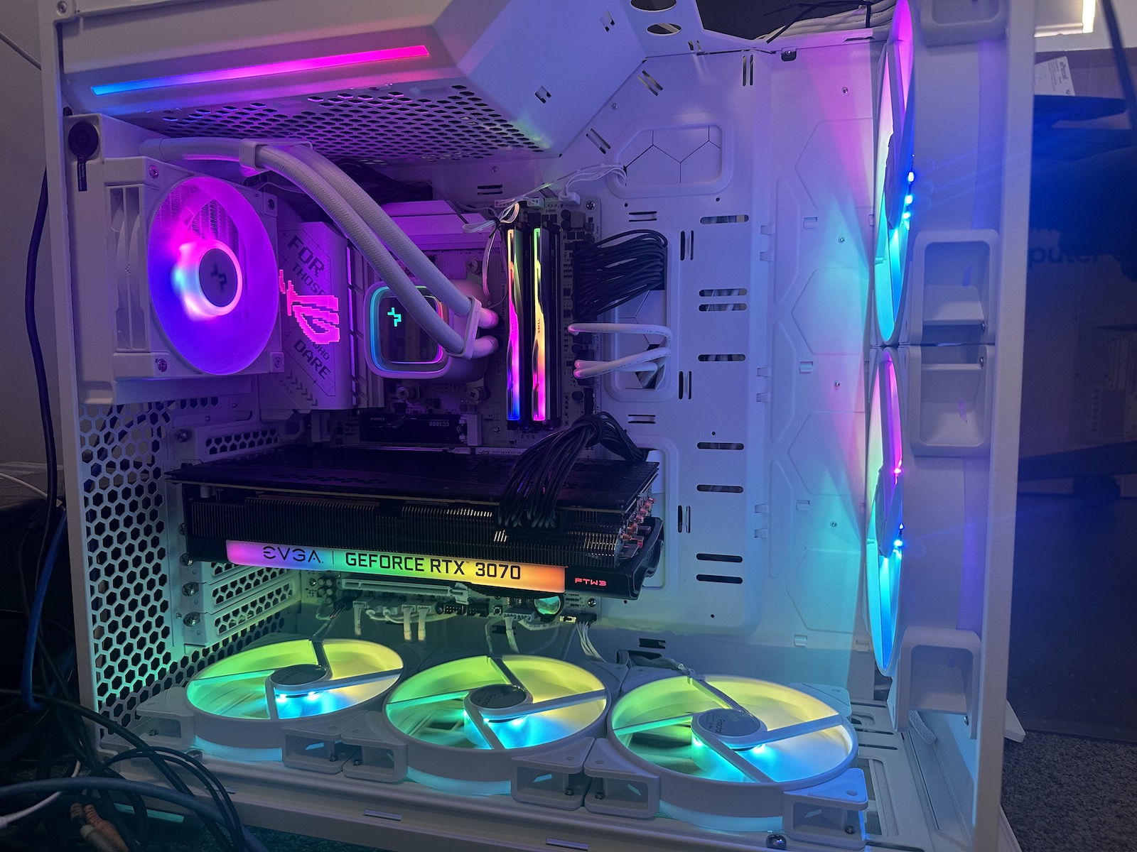A mostly-white PC, fully-built and turned on, with RGB turned on