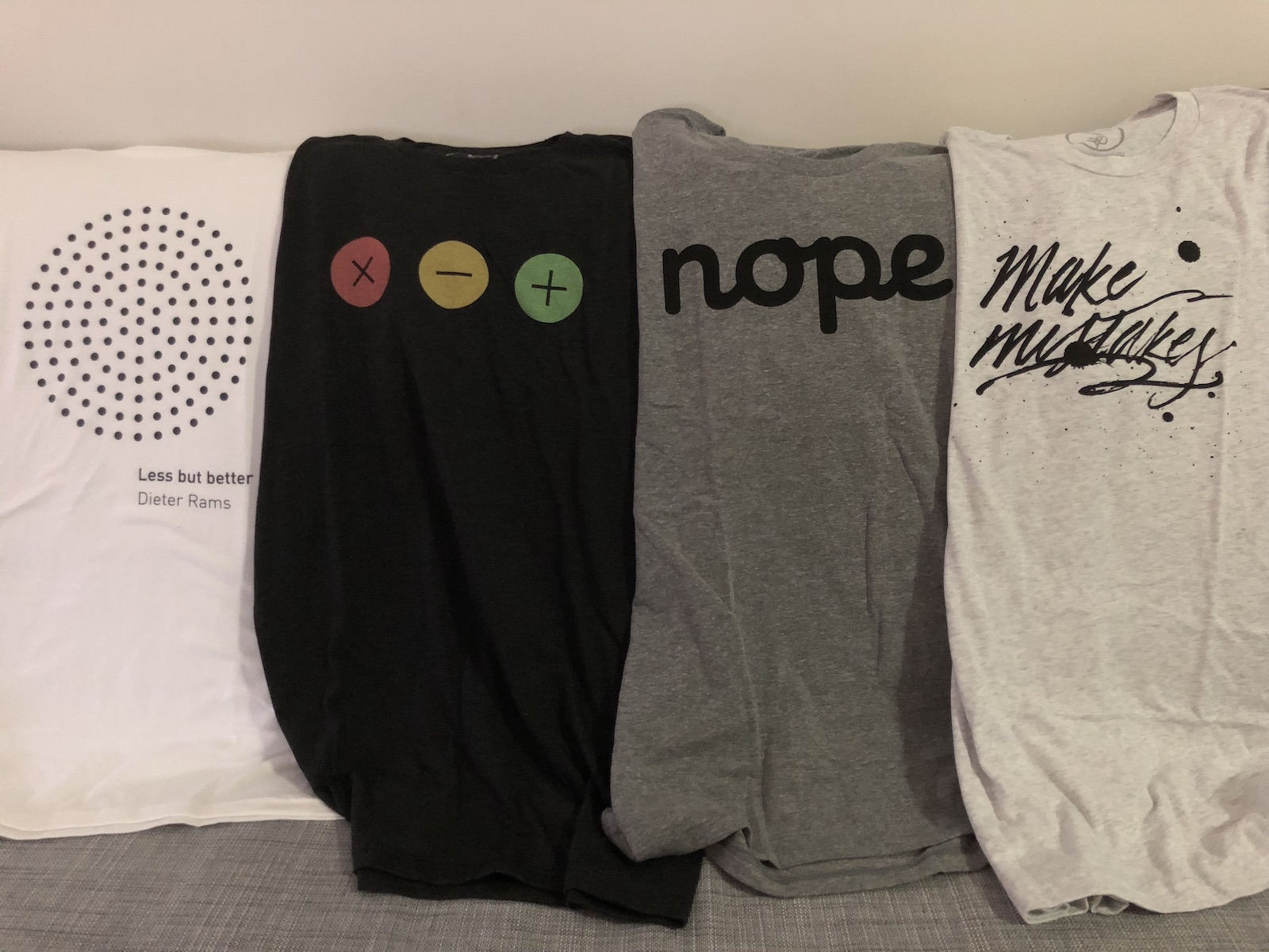Four tee shirts, one of which says make mistakes